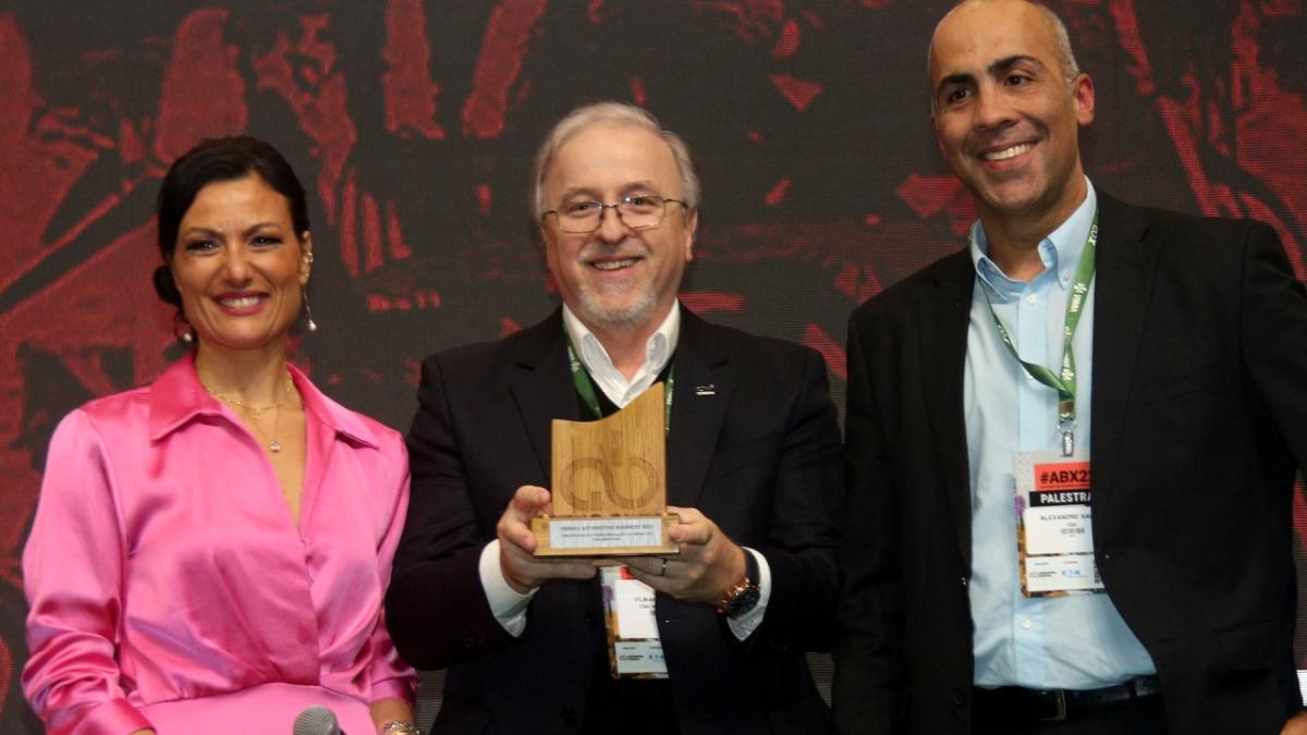 Vilmar Fistarol receives a 2022 AB Award for CNH Industrial’s innovations 三个人中间的人拿着一个奖杯