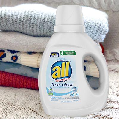 The renewable-based surfactants will be used in Henkel’s laundry product brands, including many varieties of Persil®, Purex® and all® brands. 一瓶清洁剂和一堆折叠衣服。
