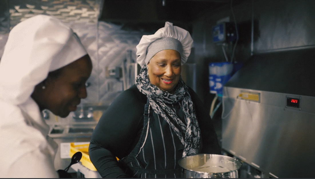 Chef Cherie Beasley of Kitchen Food Ventures, a community-based nonprofit, demonstrates a crab and shrimp bisque soup and cornbread muffins using induction cooktops and energy-efficient ovens. 厨师切丽比斯利厨房厨师的帽子