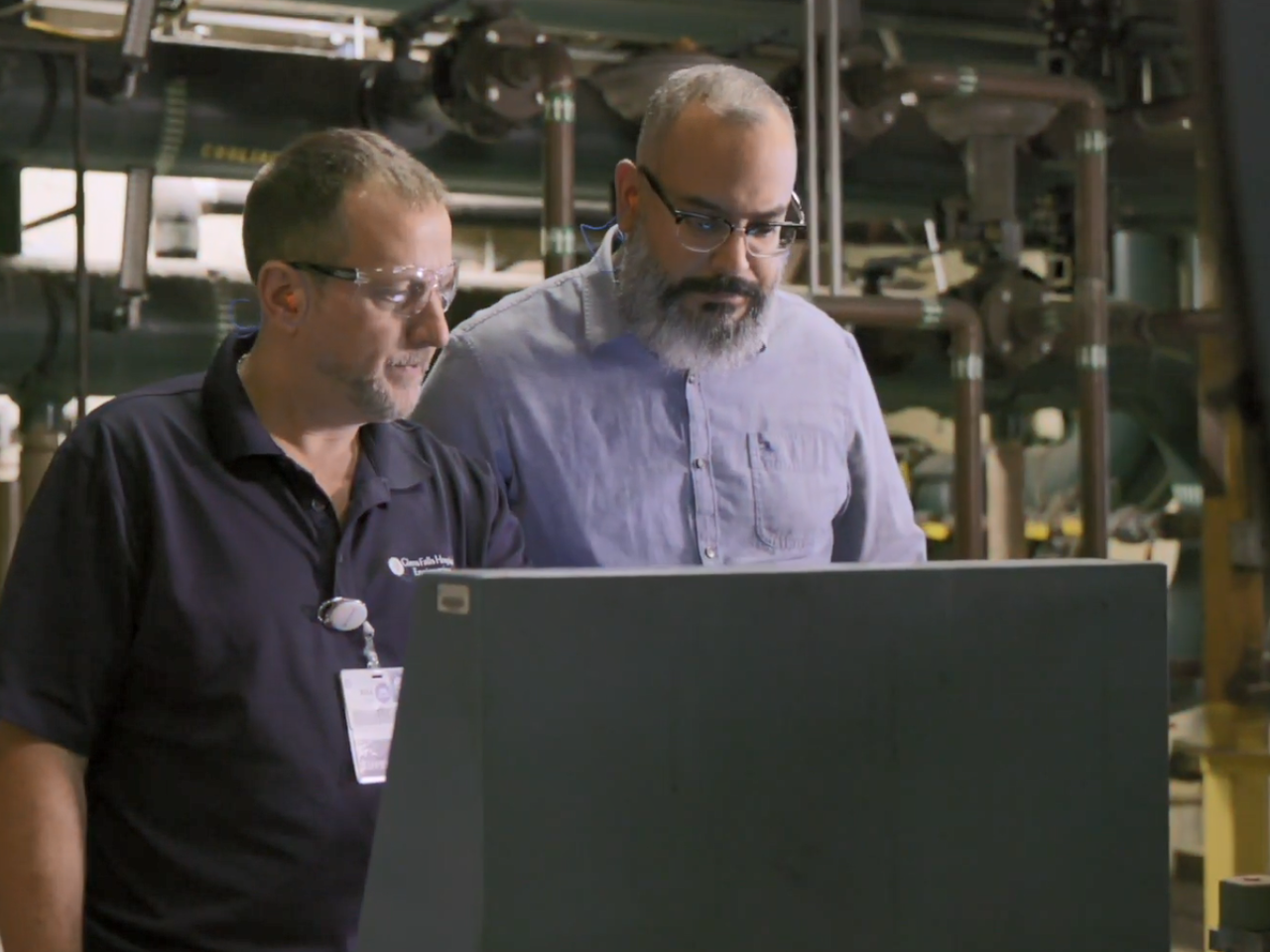 两个人用ma管道和电线看屋子屏幕