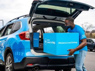 Loading a box into the back of a Subaru
