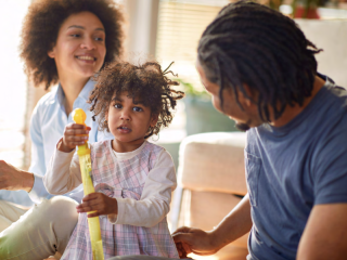 一个家庭和女儿坐在玩具上。