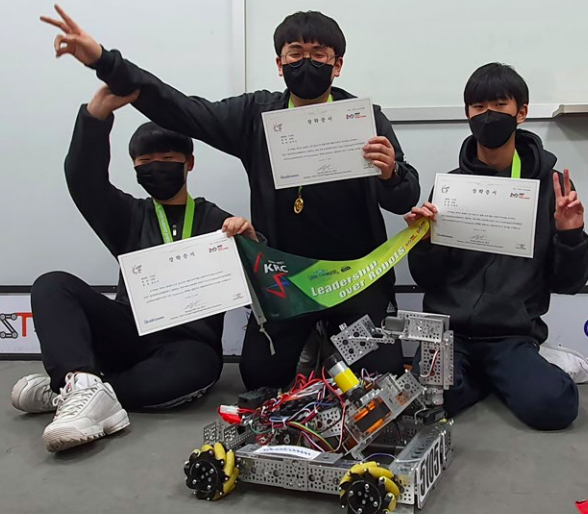 3学生跪在一个机器人